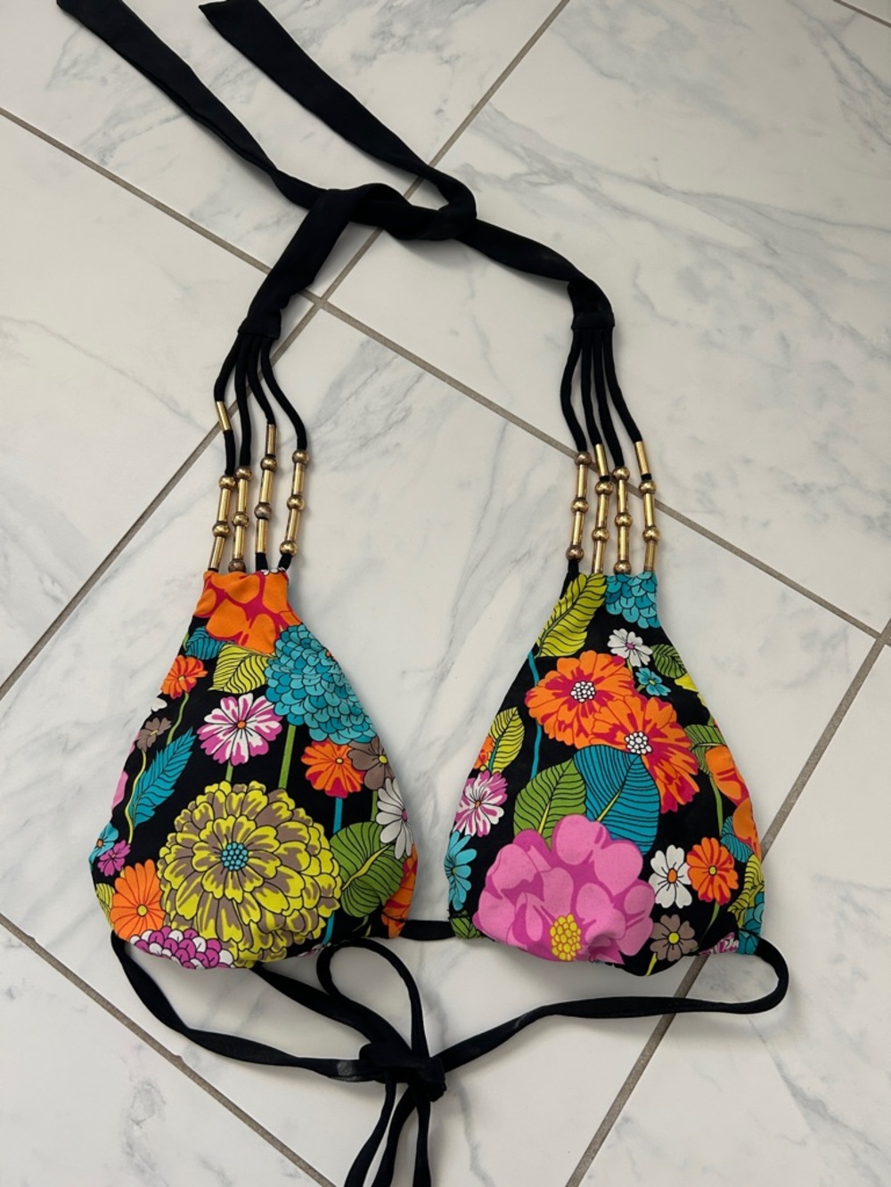 Women’s multi color swimsuit top with gold accents.